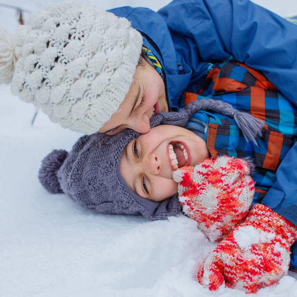 Glada barn som leker på snöig vinterdag. — Stockfoto