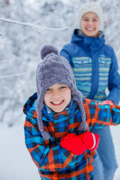 雪の降る冬の日に遊んでいる幸せな子供たち. — ストック写真