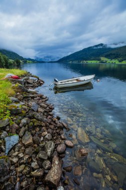 Su ile Norveç dağlarında üzerinde yelken balıkçı teknesi.