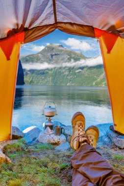 Trekking botları biri bir çadırda. Norveç Fiyordu görünümünü.