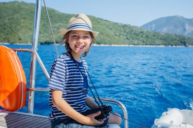 Little boy on board of sailing yacht on summer cruise. Travel adventure, yachting with child on family vacation. clipart