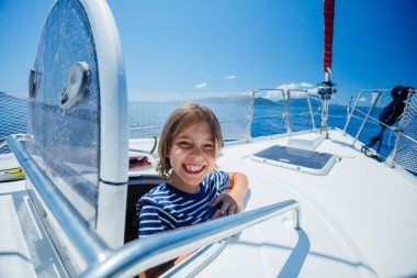 Küçük çocuk yaz gezisinde yelkenli yatında. Seyahat macerası, çocuğuyla yat gezisi..