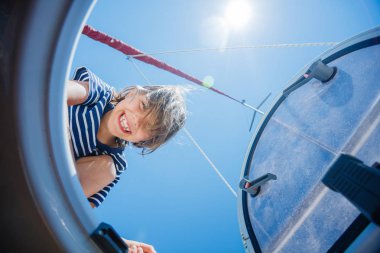 Küçük çocuk yaz gezisinde yelkenli yatında. Seyahat macerası, çocuğuyla yat gezisi..