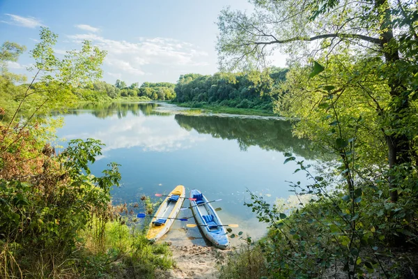 Opblaasbare boten op de kiezelstenen oever van de rivier. Kajaks in helder water — Stockfoto