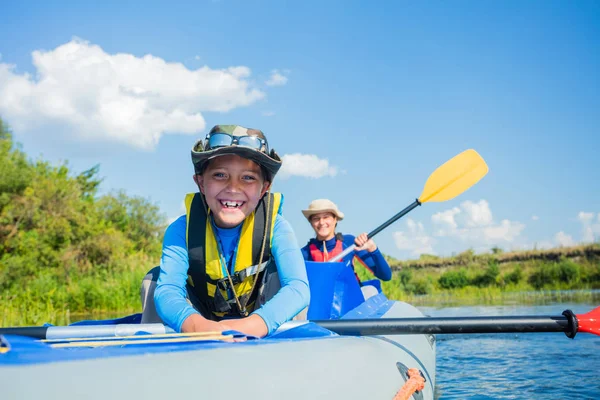 暑假里，一个阳光灿烂的日子，快乐的男孩在河里划船 — 图库照片