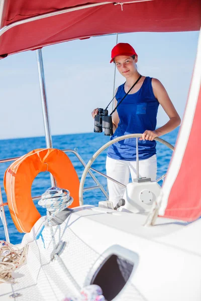 Capitano ragazza a bordo di yacht a vela in crociera estiva. Avventura di viaggio, yachting con bambino in vacanza in famiglia . — Foto Stock