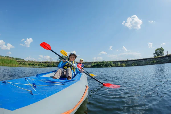 Ragazzo felice kayak sul fiume in una giornata di sole durante le vacanze estive — Foto Stock