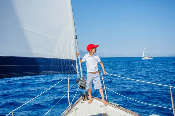 Маленький хлопчик на борту вітрильної яхти в літньому круїзі. Подорожі пригоди, яхтинг з дитиною на сімейні канікули . — стокове фото