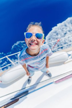 Little boy on board of sailing yacht on summer cruise. Travel adventure, yachting with child on family vacation. clipart