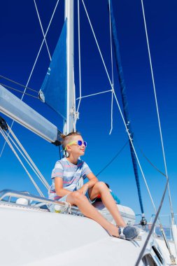 Küçük çocuk yaz gezisinde yelkenli yatında. Seyahat macerası, çocuğuyla yat gezisi..