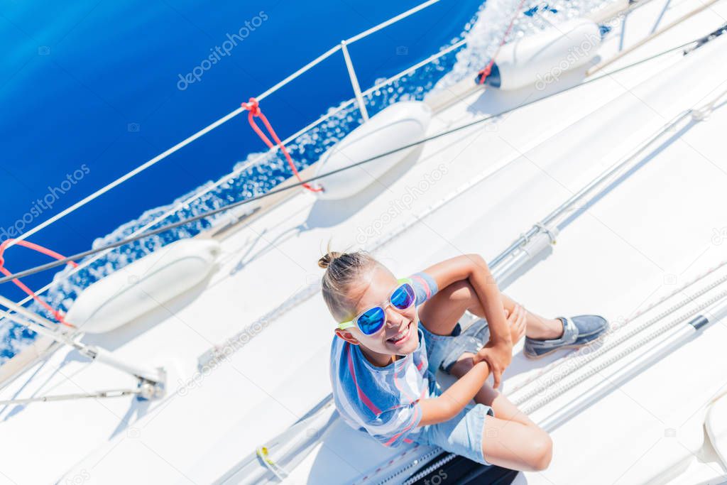 Little boy on board of sailing yacht on summer cruise. Travel adventure, yachting with child on family vacation.