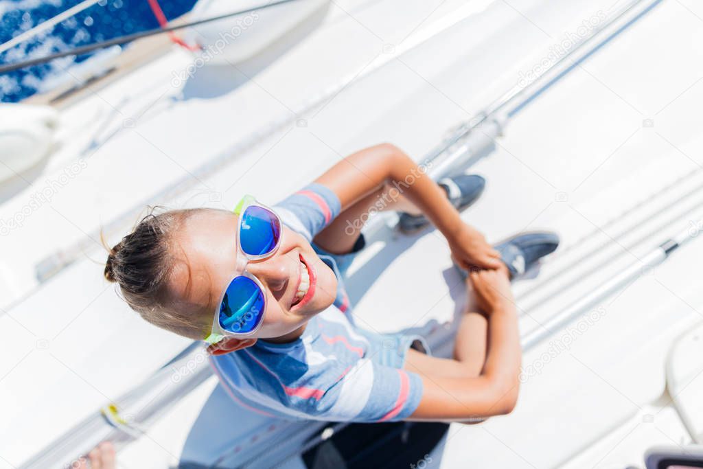 Little boy on board of sailing yacht on summer cruise. Travel adventure, yachting with child on family vacation.