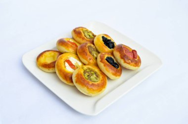 Çeşitli küçük güzel mini pizza beyaz bir plaka üzerinde