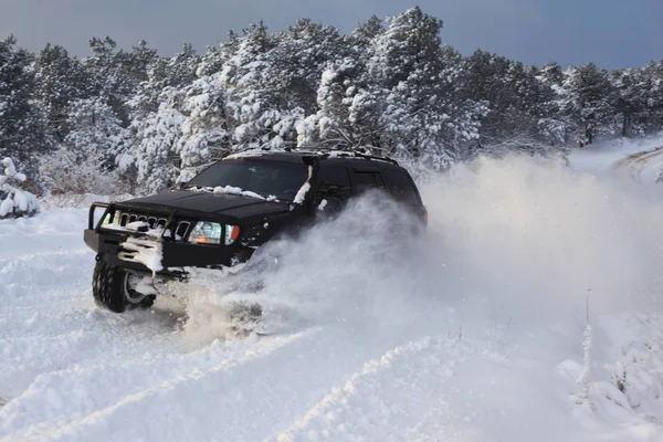 Ένα Suv Αυτοκίνητα Πηγαίνουν Χιονισμένο Δρόμο — Φωτογραφία Αρχείου