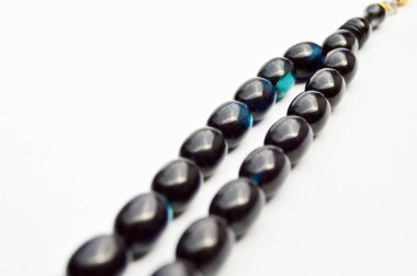 Mavi ve siyah boncuklar sıralanmış, kısa tespih, Türk kültürü için önemli bir aksesuar, beyaz arka planda izole edilmiş..