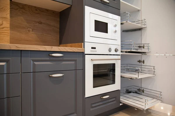 Интерьер роскошной деревянной современной кухни серые белые шкафы — стоковое фото
