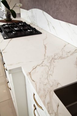 Modern temiz mutfak ve siyah gaz fırını.