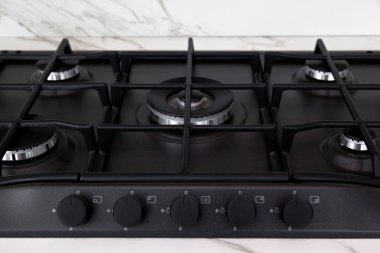 Modern temiz mutfak ve siyah gaz fırını.