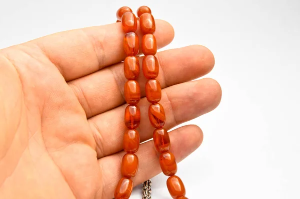 Di tangan manik-manik oranye dan perak diurutkan, rosario pendek, tespih — Stok Foto