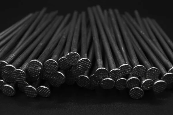 Stos gwoździ z żelaza budowlanego na czarnym, izolowanym tle — Zdjęcie stockowe