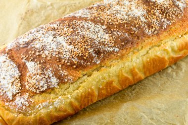 Taze pişmiş besin ve bej kağıda izole edilmiş ev yapımı altın renkli ekmek.