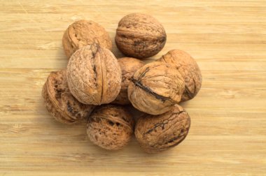 Sağlıklı ve besleyici bej kahverengi ceviz taneleri, bambu kesme tahtasında.