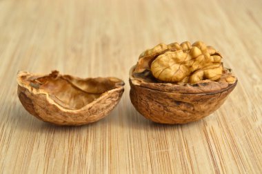 Sağlıklı ve besleyici bej kahverengi ceviz taneleri, bambu kesme tahtasında.