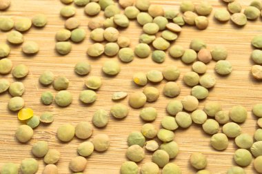 Kuru yeşil mercimek taneleri bambu kesme tahtasının üzerinde.