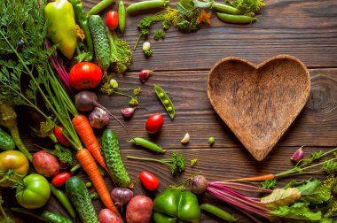 Taze organik sebze ile kahverengi kalp şekli plaka