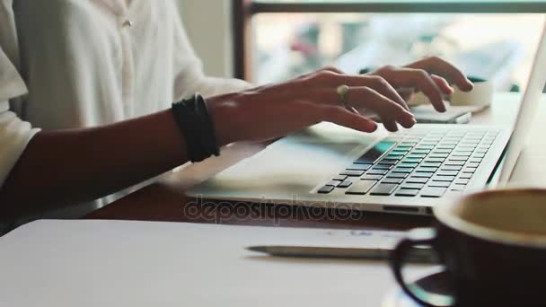 Молода жінка фрілансер друкує на ноутбуці — стокове відео