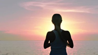 gün batımında sahilde meditasyon kadın