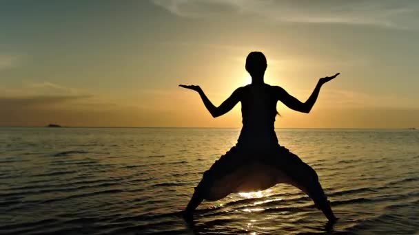 Mujer haciendo yoga en la playa al atardecer — Vídeo de stock