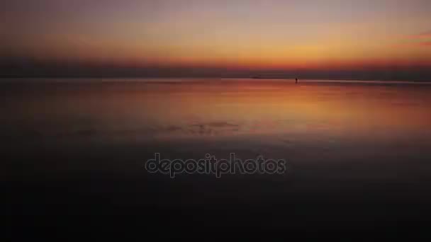 Silhouettes de deux filles heureuses courant dans la mer au coucher du soleil au ralenti — Video