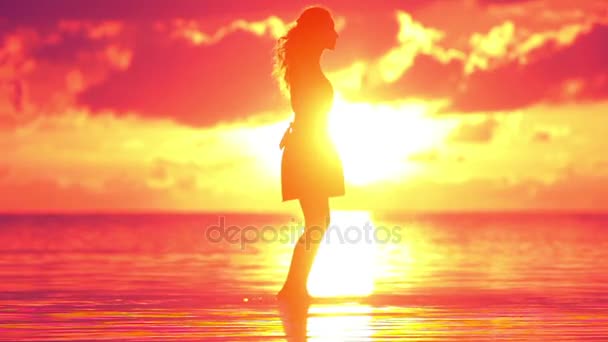 Jovem feliz girando na praia ao pôr do sol em câmera lenta — Vídeo de Stock