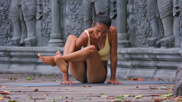 Asiática joven haciendo hatha yoga en abandonado templo — Vídeo de stock