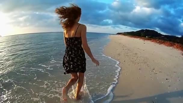 Девушка бежит по пляжу на закате — стоковое видео