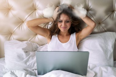 Dizüstü bilgisayar ile genç kadın buğulanmış kafasını tutuyor