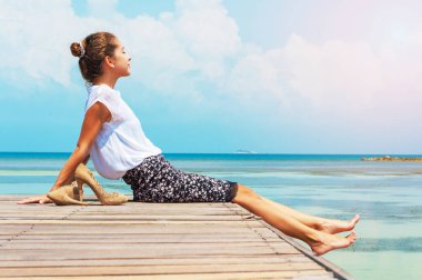 Güneş ışığı önünde oturan bir genç bayan. Plajda çalışan Bayan serbest meslek.