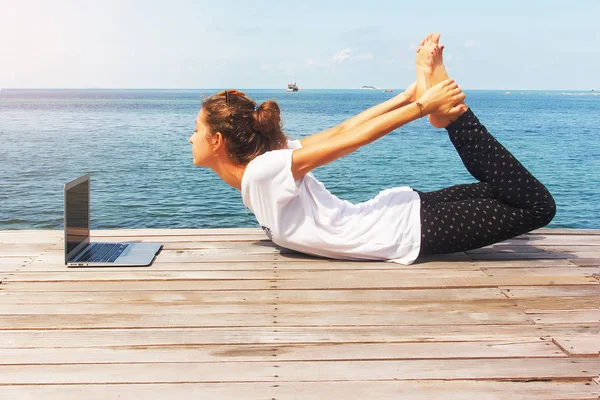 Menina tem uma prática de ioga com laptop — Fotografia de Stock
