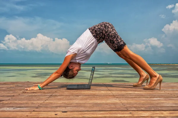Vrouw in office pak doen yoga met laptop — Stockfoto