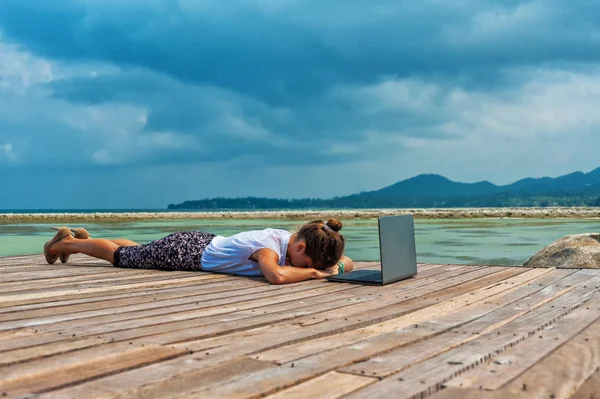 Женщина в офисном костюме занимается йогой с ноутбуком — стоковое фото