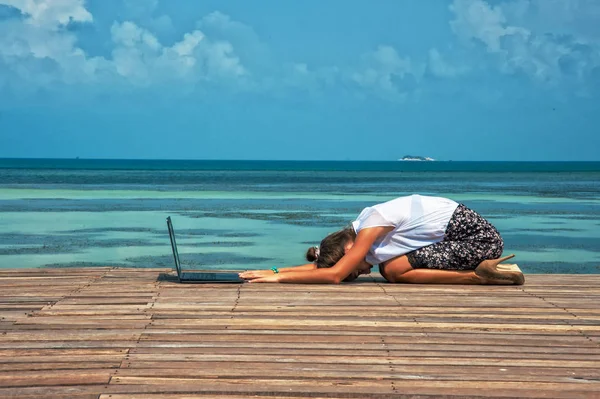 Жінка в офісному костюмі робить йогу з ноутбуком — стокове фото