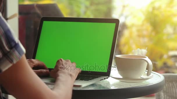Крупним планом чоловічі руки використовують ноутбук у кафе з зеленим екраном — стокове відео