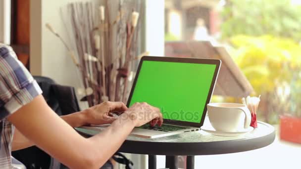 Primer plano de las manos masculinas utilizando el ordenador portátil en la cafetería con pantalla verde — Vídeo de stock