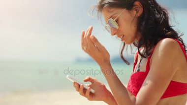 Sahilde telefonunu kullanarak çekici genç kadın