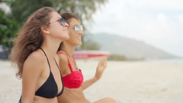 Wide Shot Dos mujeres tomando el sol en la playa — Vídeo de stock