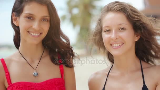 Привлекательные женщины на пляже улыбаются перед камерой — стоковое видео