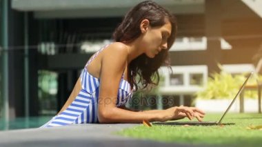 kadın modeli çalışma serbest yüzme havuzunda laptop.