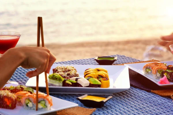 Gün batımını plajda Japon suşi ile akşam yemeği