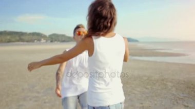 lezbiyen çift birbirine çalıştırın ve bir kumsalda kucaklamak